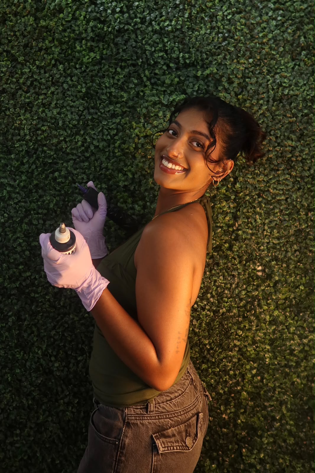 Mathusha, tattoo artist and founder of Sembaruthi Ink, holding her tattoo machine