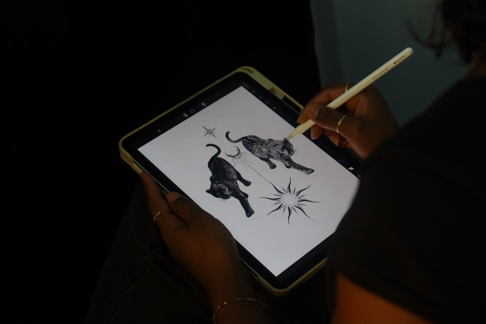 A panther and sun design taking shape on Mathusha's tablet